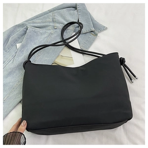 Vue à plat du sac cabas noir mat minimaliste avec détails de corde et embouts métalliques