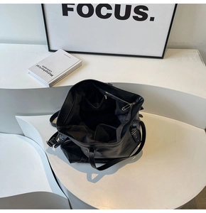 Detail of spacious interior with pockets and zip compartment in a black leather tote bag