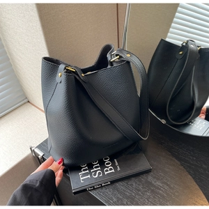 Vue détaillée du sac seau en cuir grainé noir avec des finitions en métal doré mat