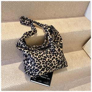Detailed close-up of leopard print canvas tote bag featuring a knotted shoulder strap detail