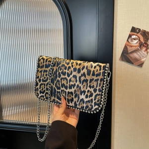 Detail of leopard print crossbody bag with silver metal studs and elegant chain strap