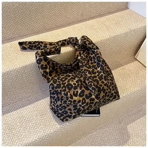 Detail of trendy leopard print canvas tote bag with unique decorative knotted handles