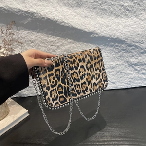 Detail of leopard print crossbody bag with silver studs and metal chain strap