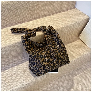 Detailed view of leopard print tote bag with wide strap on light carpet stairs