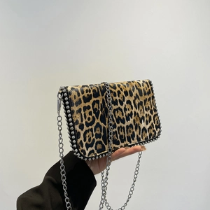 Detail view of leopard print texture and silver rivet studs on the chain bag