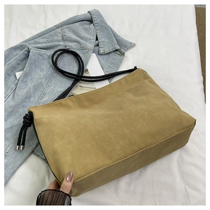 Détail du sac bandoulière en daim kaki avec bandoulière en corde tressée noire