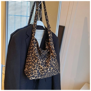 Detail of trendy leopard print canvas tote bag with wide shoulder strap on blazer