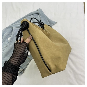 Détail du sac bandoulière en toile kaki avec bandoulière en corde noire et nœud argenté
