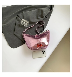 Bolso rosa metálico con textura de cocodrilo, colgante de cereza, cadena plata y smartphone