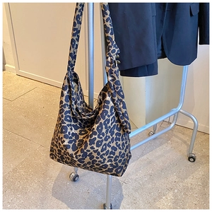 Detailed view of leopard print hobo bag hanging on a rack showing large capacity canvas material