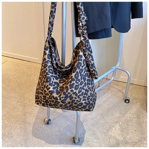 Detail of trendy leopard print canvas hobo bag with unique knotted shoulder strap