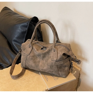 Detailansicht der braunen Vintage-Tasche mit matter Textur und Doppelreißverschluss