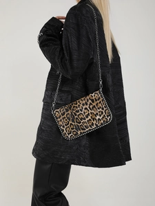 Detail of leopard print crossbody bag with iconic silver metal chain trim and flap design