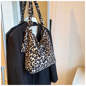Close-up of leopard print canvas tote bag featuring metal ring and knotted strap details