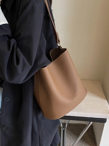 Sac seau en cuir marron caramel avec ferrures dorées porté en bandoulière pour femme