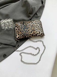 Detail of leopard print crossbody bag with silver stud trim and metal chain strap