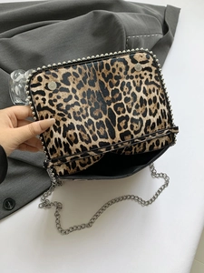 Detail shot of leopard print crossbody bag with silver stud trim and interior space