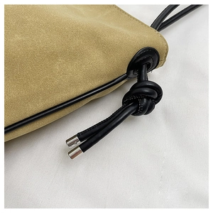 Détail du sac en daim kaki avec cordon de serrage en cuir noir et embouts en métal