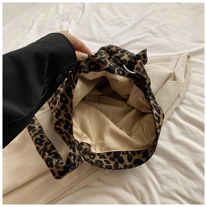 Detail showing spacious leopard print tote interior with beige lining and zipper pocket