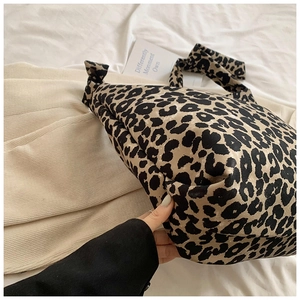Macro detail of large leopard print canvas tote bag with textured fabric surface