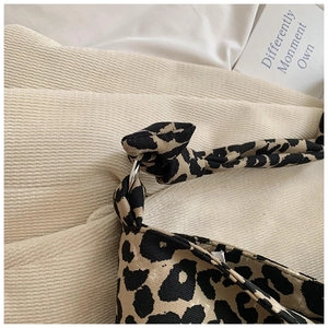 Detail of leopard print canvas bag showing silver ring buckle and knot strap design