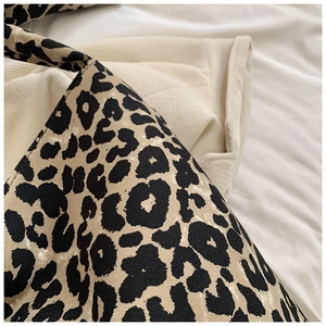Close-up detail of leopard print canvas fabric texture and stitching on the tote bag
