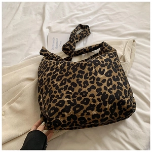 Detail of trendy leopard print canvas tote bag with wide shoulder strap and soft texture