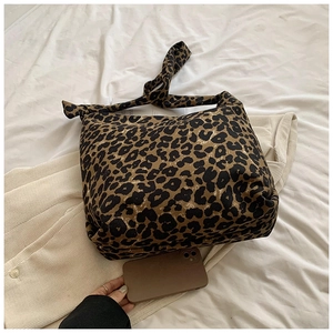 Close-up of a stylish leopard print canvas tote bag with wide matching shoulder strap