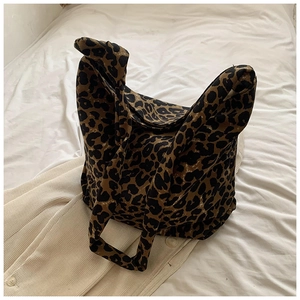 Close-up detail of leopard print canvas tote bag with large pattern on white fabric
