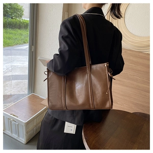 Braune Vintage-Tote Bag aus Kunstleder mit langen Riemen, von hinten am Modell gezeigt