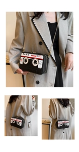 Close-up of retro cassette tape shaped shoulder bag with golden chain and zipper