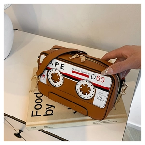 Close-up of retro brown cassette tape shoulder bag with vintage chain strap and zipper