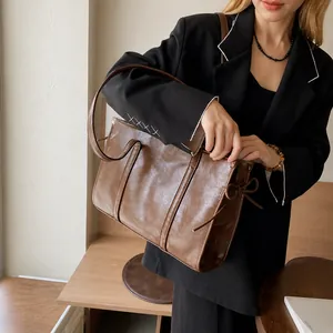 Détail du sac cabas marron vintage avec nœuds décoratifs et texture en cuir lisse