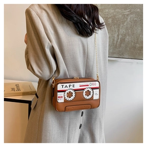 Detail of vintage cassette tape crossbody bag in brown leather with gold chain strap