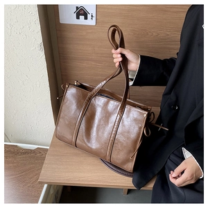 Detailansicht einer braunen Vintage-Einkaufstasche aus glänzendem Kunstleder mit Tunnelzug