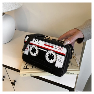 Detailed macro view of vintage cassette-shaped crossbody bag with gold hardware