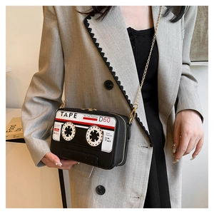 Detail of creative cassette tape shaped crossbody bag with gold chain and black texture