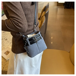 Dettaglio di una borsa a secchiello vintage blu-grigio opaco con fibbia e coulisse