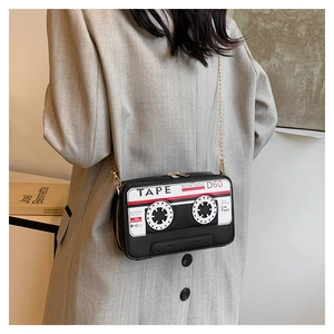 Detailed close-up of retro cassette tape shaped crossbody bag with gold chain strap