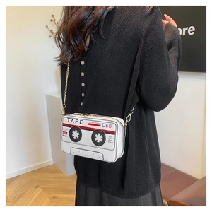 Detailed side view of white cassette tape crossbody bag with a gold chain strap