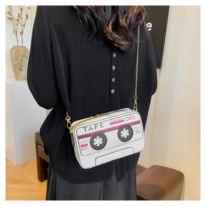 Detail shot of a retro cassette tape crossbody bag with a gold metal chain strap