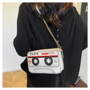 Close-up of creative retro cassette tape handbag with metal chain strap on a model