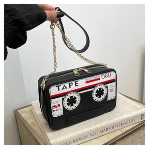 Close-up of retro cassette tape shaped handbag with golden hardware and chain strap
