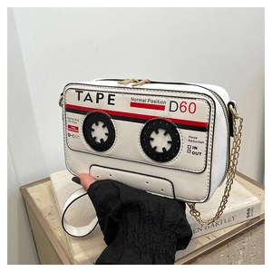 Detailed macro of vintage tape-shaped white crossbody bag with golden chain and dual zippers
