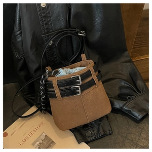 Dettaglio borsa a secchiello marrone caffè con cinture nere e coulisse azzurra