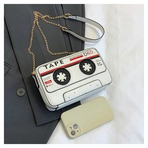 Detail shot of the vintage tape cassette shape and logo on white leather crossbody bag