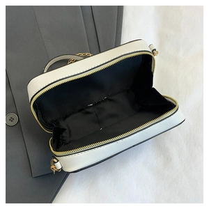Detailed interior view of white cassette bag with black lining and gold zipper