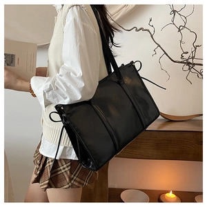 Detail der schwarzen Shopper-Tasche mit Kordelzug in einer retro-ästhetischen Szene
