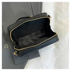 Macro view of black cassette tape bag interior with golden double zippers and inner lining