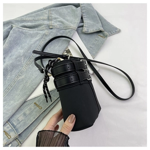 Dettaglio borsa a secchiello in nylon nero con chiusura a coulisse e fibbie metalliche